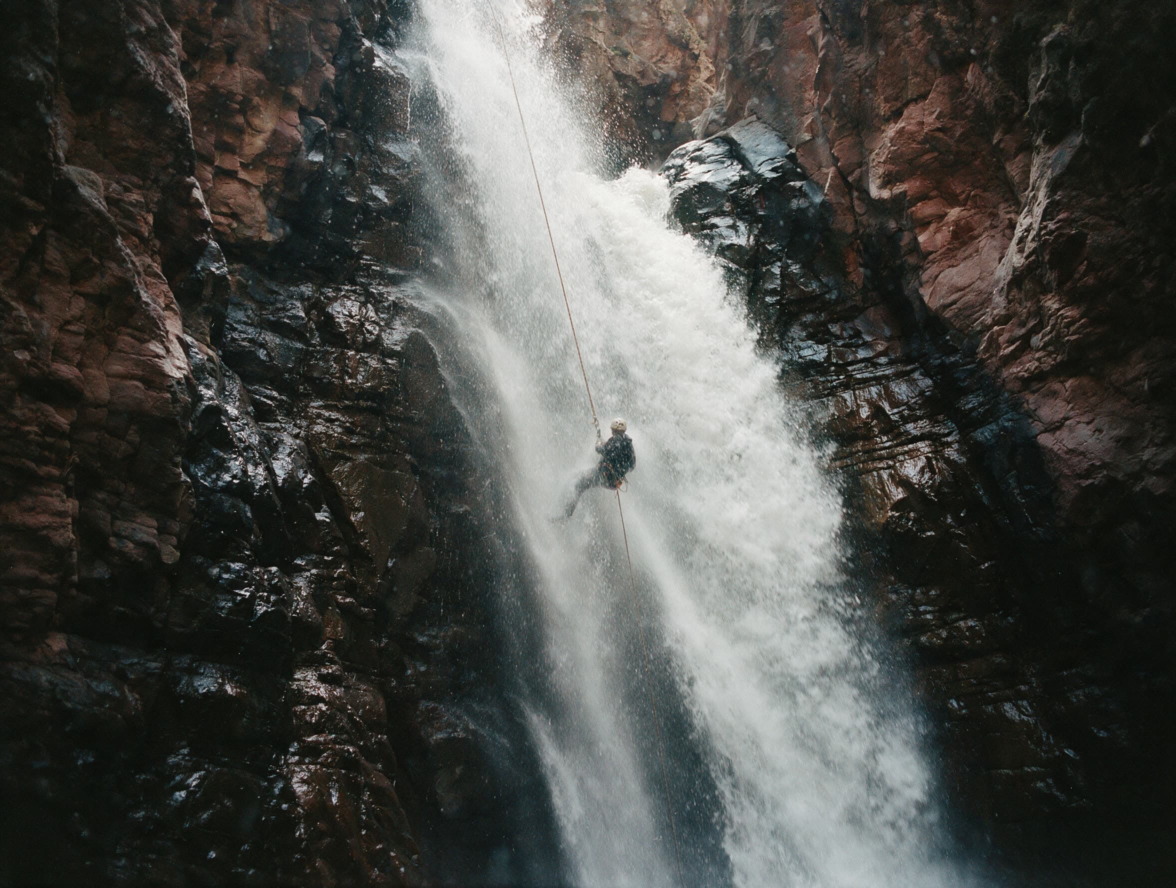 Canyoneer seilt sich frei hängend neben einem hohen Wasserfall in Wajots Dsor ab