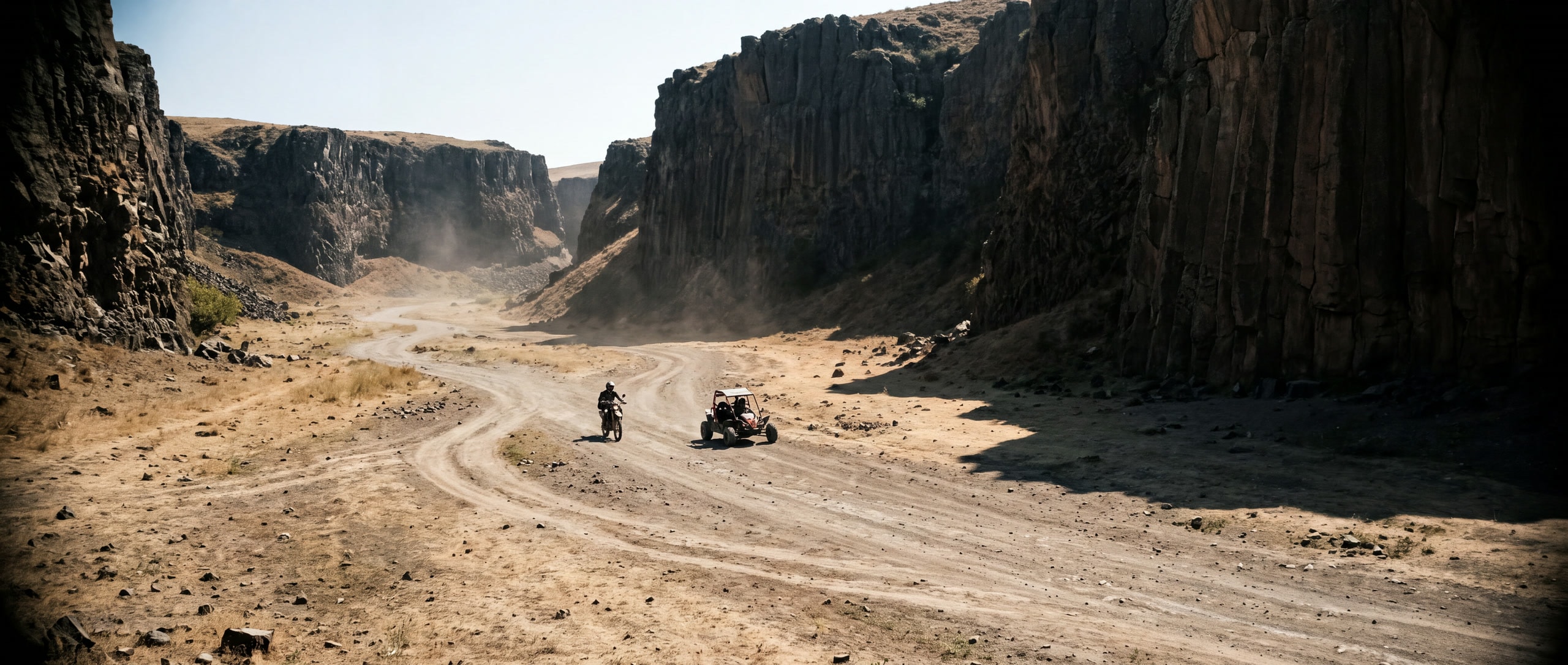 Een endurofiets en een buggy klein in de droge basaltkloof bij Garni