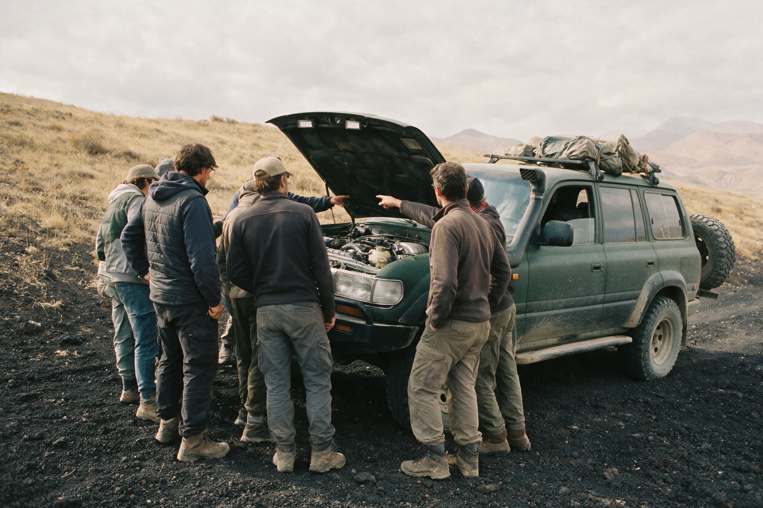 Een groep van achteren bij de open motorruimte van een terreinwagen tijdens de instructie