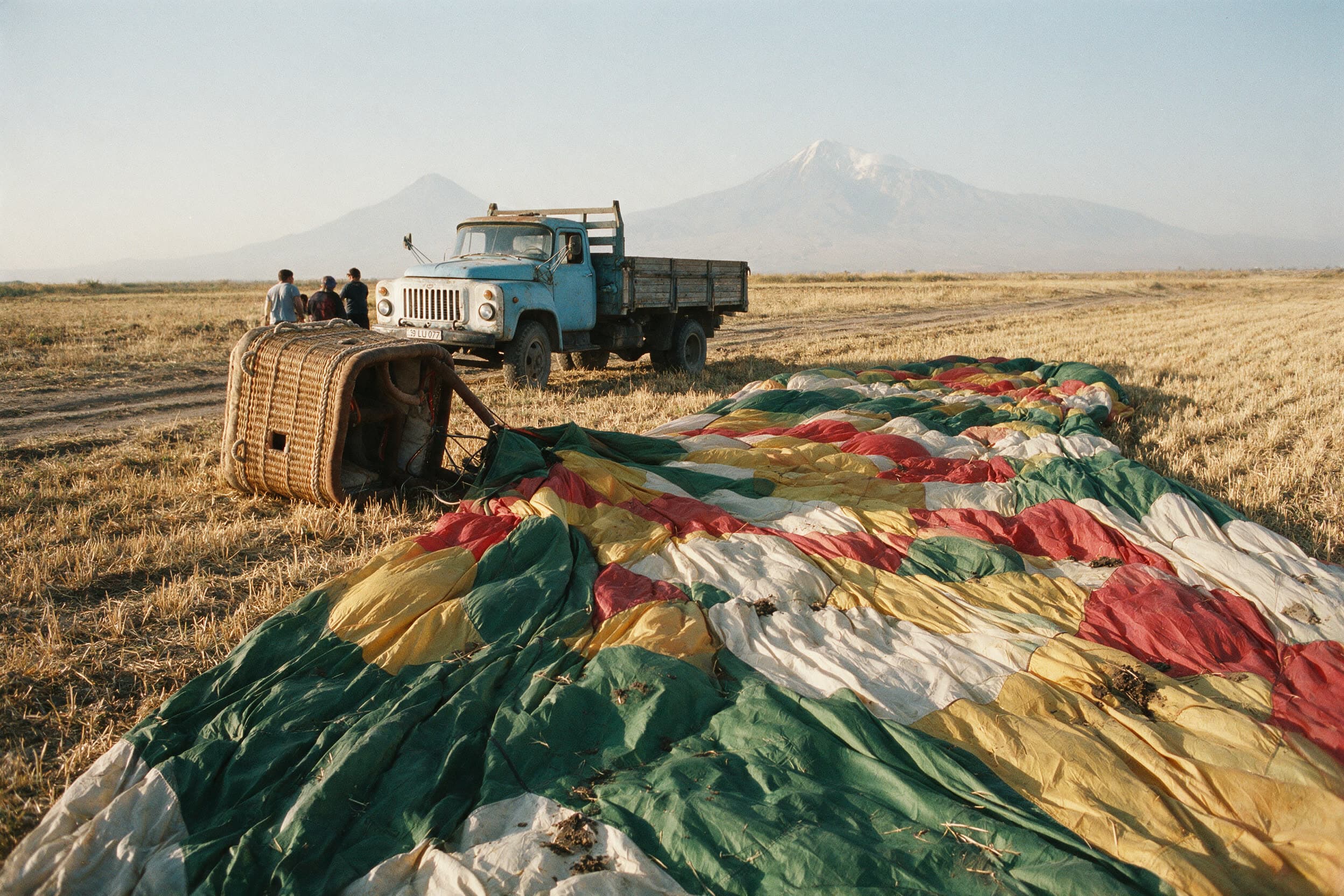 Een leeggelopen ballonhuid over een stoppelveld in de Araratvlakte na de landing