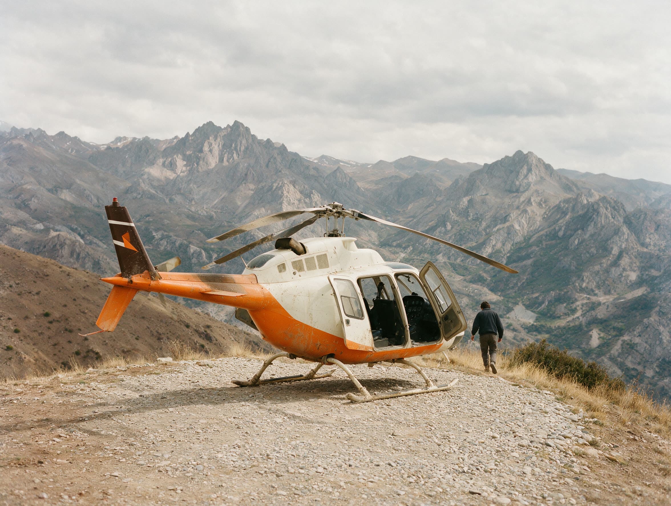 Kleiner Hubschrauber auf einem Schotterplatz an einer kahlen armenischen Bergschulter