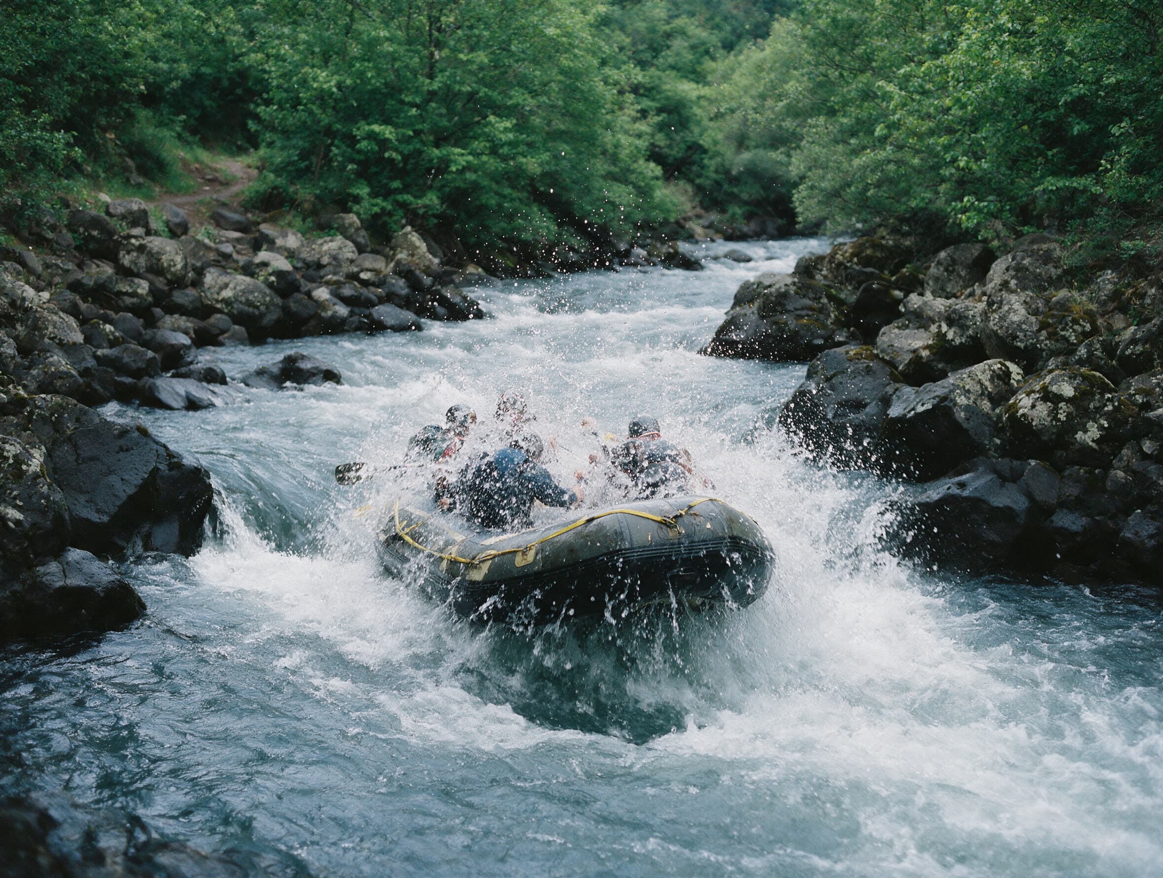 Schlauchboot mit fünf Paddlern in einer Stromschnelle des Aghstew in Tawusch