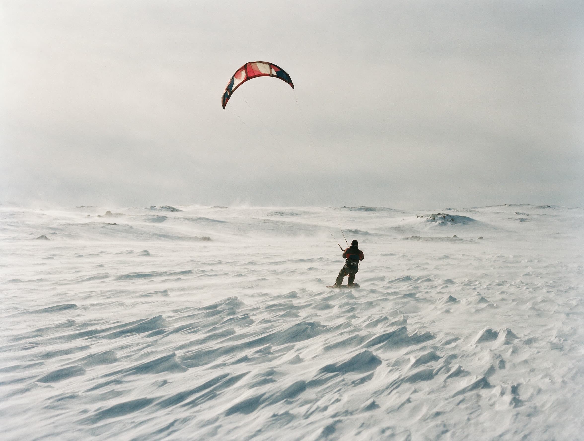 Snowkiter von hinten auf einer verwehten Schneeebene der Aragaz-Hochfläche