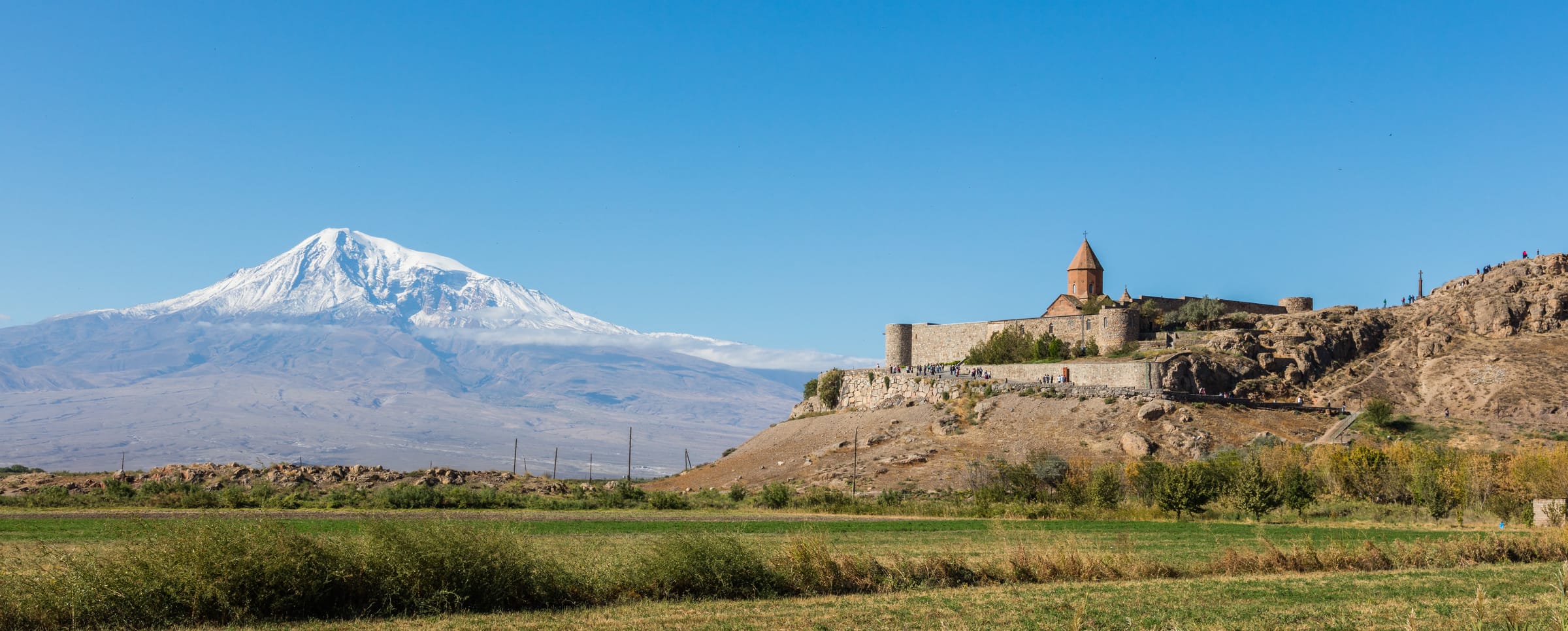 Khor Virap monastery on its hill in the Ararat plain with snow-covered Mount Ararat behind